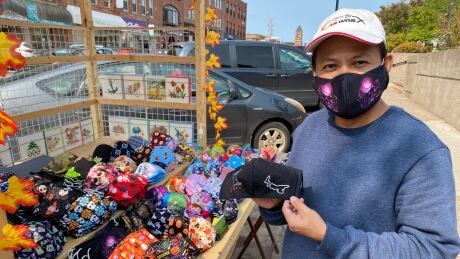 Tony Nguyen, owner of Q Pop Up Cards, holds up some of the face masks for sale at his stand in downtown Charlottetown that saw brisk sales during the lunch rush. Taken Sept 17, 2020. Tony Nguyen selling masks in Charlottetown