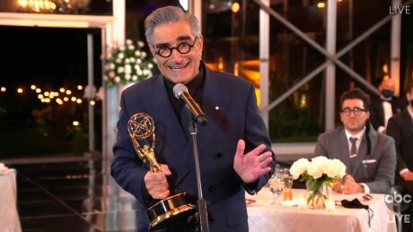 In this video grab captured on Sept. 20, 2020, courtesy of the Academy of Television Arts & Sciences and ABC Entertainment, Eugene Levy accepts the outstanding lead actor in a comedy series award for "Schitt's Creek" as his son and castmate Dan Levy looks on at right during the 72nd Emmy Awards broadcast. 2020 Primetime Emmy Awards