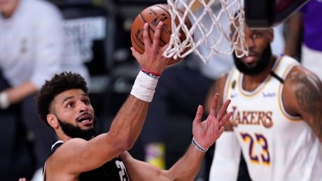 Denver's Jamal Murray, left, goes up for a shot attempt as Los Angeles' LeBron James, right rear, looks on during the second half of the Nuggets' 114-106 victory over the Lakers in Game 3 of the Western Conference finals on Tuesday. murray-jamal-092220