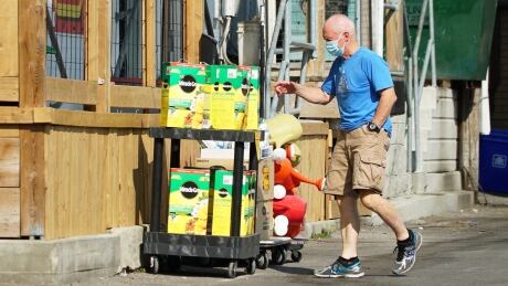 A man looks at gardening products in uptown Waterloo. Uptown Waterloo man wearing mask