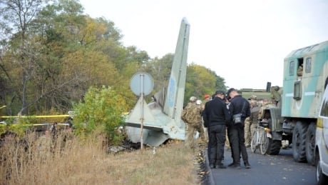 Military and experts work on the place of the Antonov-26 transport aircraft crash at Chuhuiv military air base around 30 kilometers southeast of Kharkiv on September 26, 2020. - 23 people including military cadets were killed when a Ukranian air force plane crashed near Kharkiv in the east of the country. The Antonov-26 transport plane was carrying 20 cadets and seven crew when it crashed late on September 25 two kilometres (about one mile) from the Chuguiv military air base near the city of Kharkiv. (Photo by SERGEY BOBOK / AFP) (Photo by SERGEY BOBOK/AFP via Getty Images) 1228716144