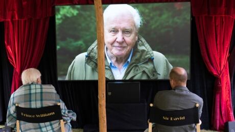 In this undated handout photo issued by WWF on Saturday, Sept. 26, 2020, British Naturalist Sir David Attenborough, sits with Prince William for a private outdoor screening of his upcoming film, David Attenborough: A Life On Our Planet, at Kensington Palace, London. Britain Royals Attenborough