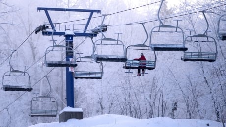 A downhill skier rides the lifts at Camp Fortune in Chelsea, Quebec on Tuesday, Dec. 24, 2013. A -31 C wind chill was expected in the Ottawa region Tuesday morning and a frostbite advisory was issued by Ottawa Pulic Health. THE CANADIAN PRESS/Justin Tang camp fortune skiing chair lift winter chelsea outaouais