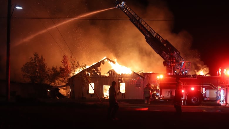A dark scene of a building on fire.