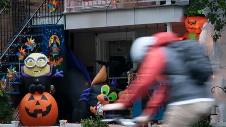 A cyclist speeds past Hallowe'en decorations in Montreal halloween decorations montreal