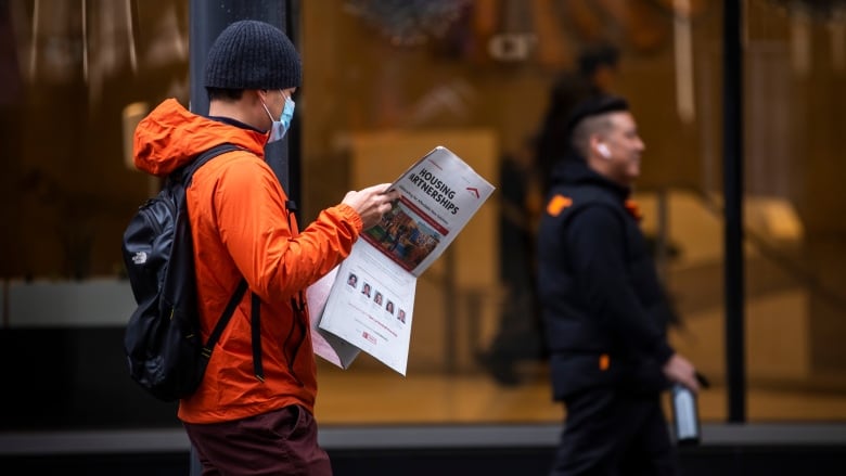 A man reads a newspaper in downtown Vancouver on Nov. 23