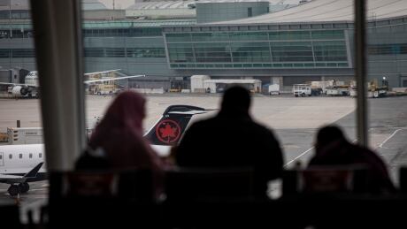Travellers and airline staff walk through a quiet Pearson airport, in Toronto, on Dec. 21, 2020 as Premier Doug Ford announces that all of Ontario will move into a lockdown starting on Boxing Day in a bid to curb climbing COVID-19 case numbers. COVID-19 TORONTO PEARSON AIRPORT LOCKDOWN