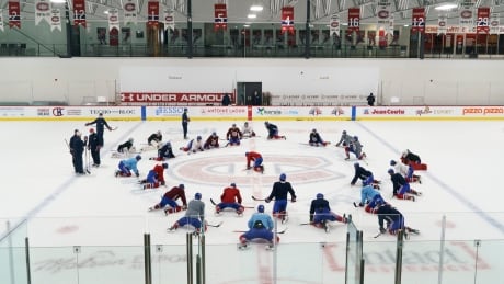 Montreal Canadiens players stretch at centre ice at their training facility during a practice in Brossard, Que. on Tuesday, January 5, 2021. HKN Canadiens Camp 20210105