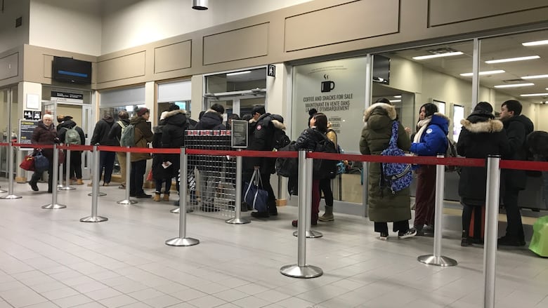 People lined up to go through security at an airport. 