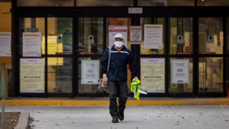 A Canada Post worker walks out of the Gateway East facility in Mississauga on Wednesday. Canada Post has confirms a major outbreak of COVID-19 at the plant. COVID-19 GATEWAY CANADA POST OUBREAK