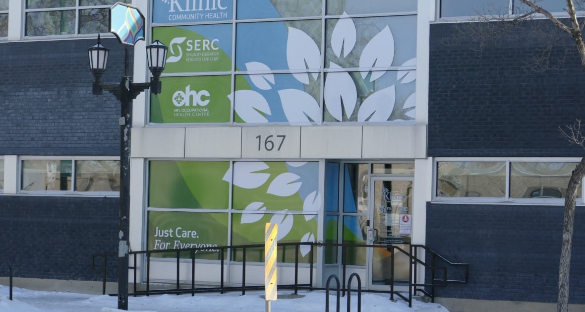 The front of a glass building with signs outside.