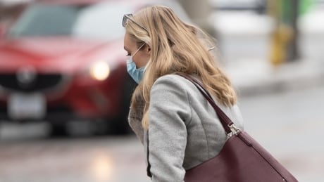 Woman wearing mask about to cross street, Bank and Queen Street, medium close-up.
Taken in Ottawa on February 18, 2021 OTTAWA MASKS pedestrian