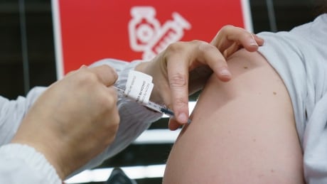 A woman receives her COVID-19 vaccine at a vaccination clinic in Montreal's Olympic Stadium on Tuesday, February 23. COVID Que 20210223