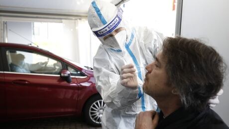 A German help worker tests for COVID-19 a French national going to Germany at the German-French border near Saarbrucken, Tuesday, March 2, 2021. Germany announced Sunday that travelers from France's northeastern Moselle region will face additional restrictions because of the high rate of variant coronavirus cases there. Travelers from this area must produce a recent negative coronavirus test before entering Germany. The Moselle region in northeastern France includes the city of Metz and borders the German states of Saarland and Rhineland-Palatinate. Virus Outbreak Germany France