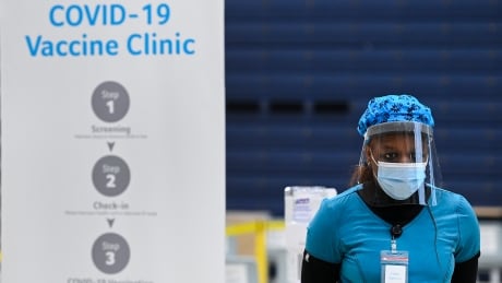 A health-care worker stands in the post vaccine waiting area at a mass COVID-19 vaccination clinic for Peel Region during the COVID-19 pandemic in Mississauga, Ont., on Monday, March 1, 2021. COVID Ont 20210301