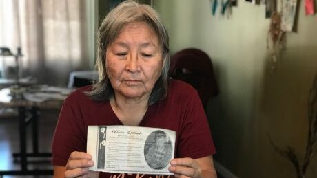 Rose Betthale-Reid holds up the obituary her family wrote for her father William, who went missing in the Petitot River in 2010. She writes to him often during the pandemic as a way to stay strong. Rose Betthale-Reid