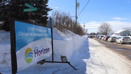 Dozens of vehicles were lined up on streets leading to the middle school as people waited to park before waiting in an outdoor line. Mass testing line Miramichi