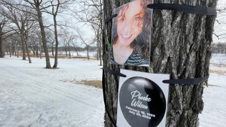 Dozens of black balloons and photos have been tied to trees along Churchill Drive in Winnipeg's Lord Roberts neighbourhood to raise awareness about lives lost to drug overdoses in Manitoba in 2020. Phoebe Wilson, 31, died in July 2020. Overdose tree tribute