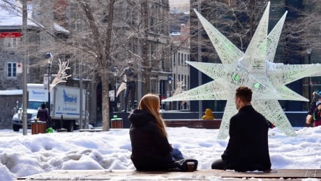 A couple chats in a park in downtown Montreal this week. Montreal park couple COVID-19