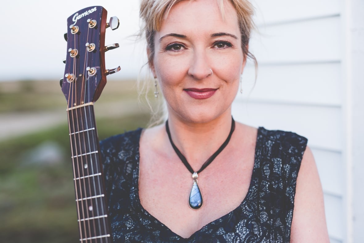 A woman holding a guitar.