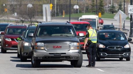 Ottawa police talk to drivers crossing into Ontario from Gatineau, Que., on April 19, 2021, the first day of strenghened pandemic rules at the border. ontario quebec ottawa gatineau border traffic bridge covid coronavirus police