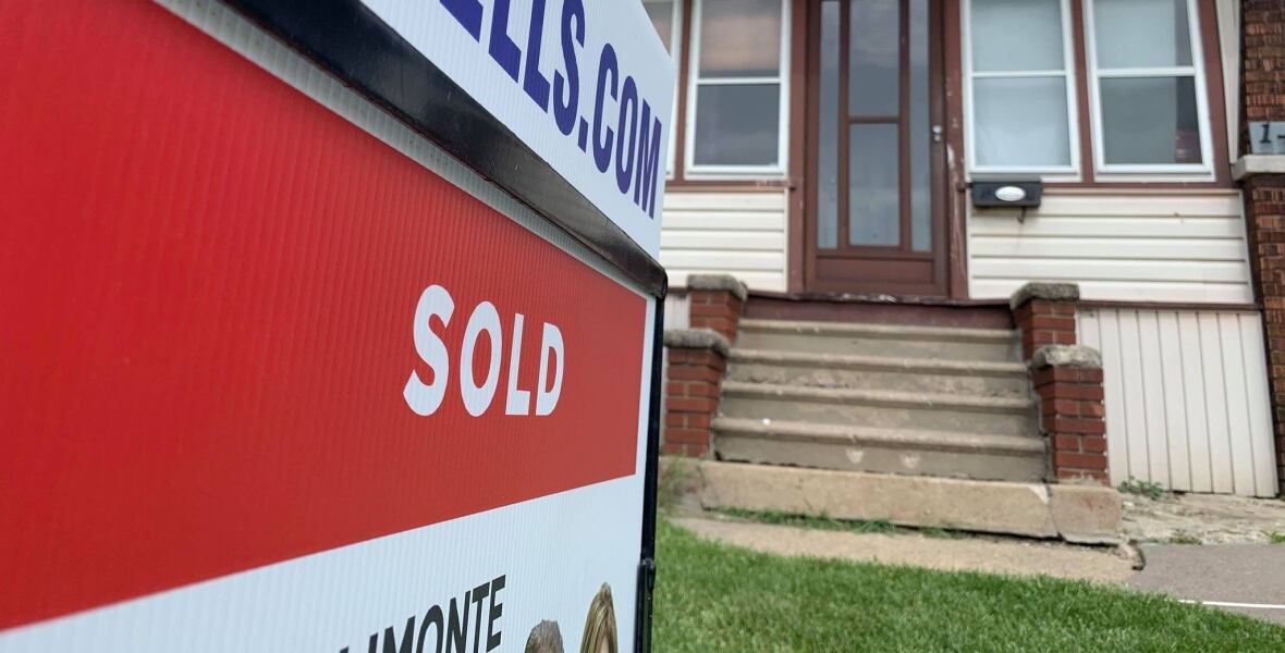 A house with a sold sign in front of it. 