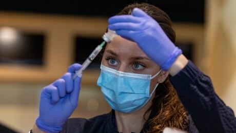 Registered nurse Sarah Moslehi prepares a dose of the Pfizer-BioNTech COVID-19 vaccine at a temporary clinic at the Woodbine racetrack and casino, in northwest Toronto, on May 5, 2021. Woodbine Racetrack Covid Vaccine Clinic
