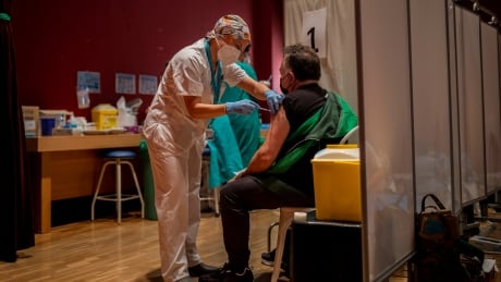 A man is administered the Pfizer COVID-19 vaccine at the Severo Ochoa Hospital in Leganes, outskirts of Madrid, Spain, Thursday, May 13, 2021. Man receives shot of Pfizer COVID-19 vaccine in Madrid