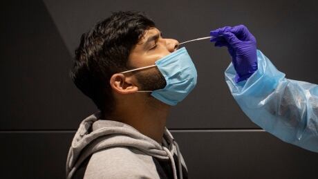Samjoe James, who had just returned to Canada from India, gets a COVID-19 test from nurse Sheryn Valencia on Feb. 1, 2021. James was among the first cohort of returning international passengers to be required to get a test as part of a new program at Pearson airport. PEARSON TESTING