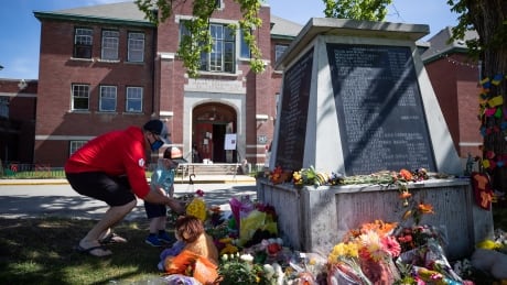 A memorial outside the former Kamloops Indian Residential School in B.C. Preliminary findings from a survey of the grounds at the school uncovered the remains of 215 children buried at the site, according to the Tk'emlúps te Secwépemc First Nation. Residential School Remains 20210531