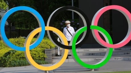 A man walks past the Olympic rings in Tokyo on Monday, June 7, 2021. Japan Tokyo Olympics