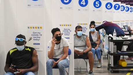 People receive mRNA COVID-19 vaccines at a mass vaccination facility in Brampton, Ontario. The technology that delivers mRNA into the body was made in part thanks to Canadian researcher Dr. Pieter Cullis. COVID Ont Hockey Rink Mass Vaccine 20210604
