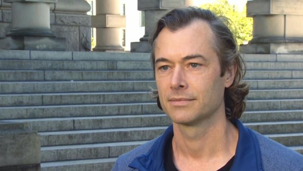 Ryan Beaton is a B.C.-based lawyer at Juristes Power Law. He is a man who is speaking in front of a series of steps.