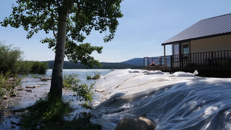 A home on Marsh Lake with a nearby berm, with water levels surrounding it.
