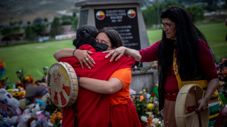 In this remarkable year of news, a note of thanks; On the grounds of the former Kamloops Indian Residential School, on Tk’emlúps te Secwépemc territory, Katherine Cooper from the Mosakahiken Cree Nation in Manitoba consoles her friends at a growing memorial to honour the children whose burial sites may have been discovered buried in Kamloops, B.C., on June 4, 2021.