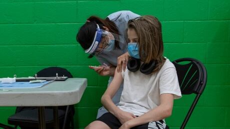 Gavin Henderson, 13, gets his first dose of the Pfizer-BioNTech COVID-19 vaccine at a clinic held at Don Bosco Catholic Secondary School, in Etobicoke, Ont., on May 19, 2021. Don Bosco Vaccine Clinic