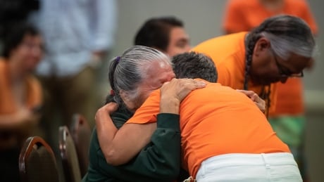 Kamloops Indian Residential School survivors Evelyn Camille, left, and Leona Thomas embrace after they spoke about their experiences at the school after the Tk'emlúps te Secwépemc First Nation released a report outlining the findings of a search of the former residential school property using ground-penetrating radar, in Kamloops, B.C., on Thursday, July 15, 2021. Residential School Remains 20210715