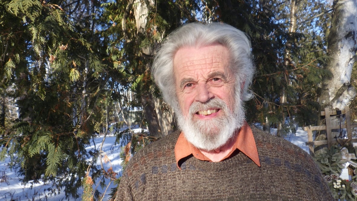 A man smiles outside.