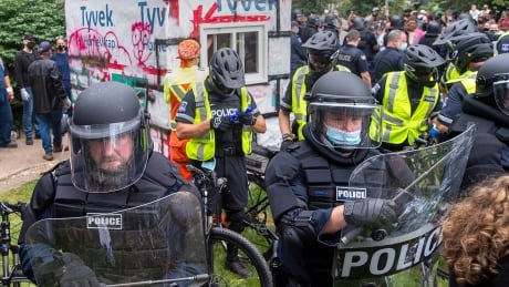 Some Halifax police officers donned riot gear as part of the efforts to remove a temporary housing shelter. The shelter was cut apart using a chainsaw. NS Shelters Protest 20210818