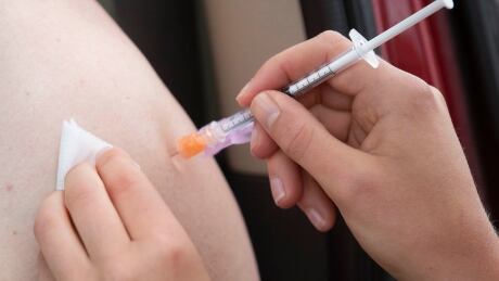 A person receives their COVID-19 vaccine during a drive-thru clinic at Richardson stadium in Kingston, Ont., on Friday, Jul. 2, 2021. THE CANADIAN PRESS/Lars Hagberg COVID Ont Kingston Clinic 20210702