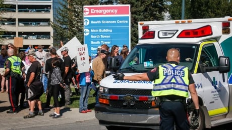 Police direct an ambulance past a protest against public health measures like COVID-19 vaccine mandates outside of Foothills hospital in Calgary on Monday. Cda Hospital Protests 20210913