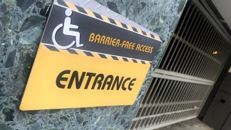 Accessibility access point for a building through a parking garage in downtown Vancouver that is behind a locked gate and has grate that is difficult to cross with a wheelchair. Accesibility