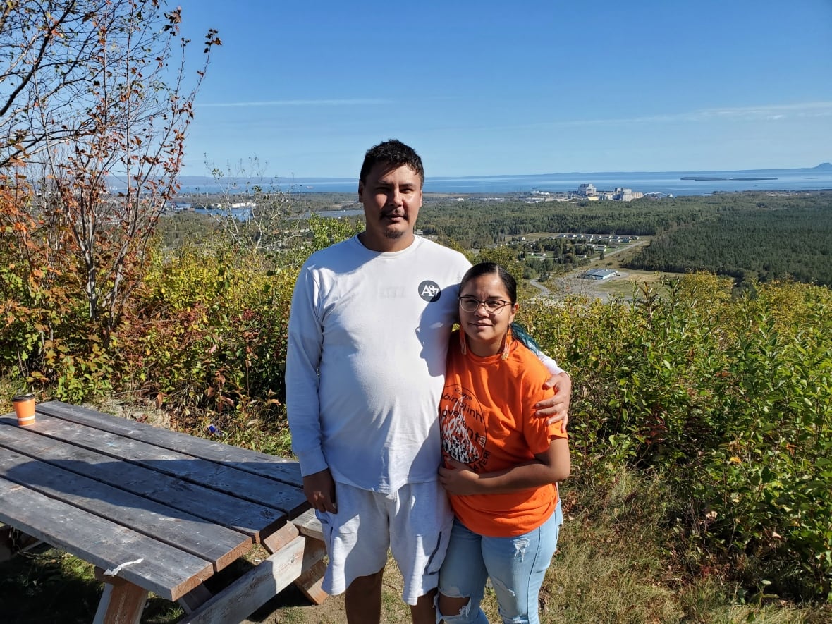 Two people smile and look at camera