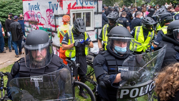 Canada's police chiefs call for more help to deal with increasing number of protests; Police attend a protest after the city removed tents and small shelters for homeless people in Halifax on Wednesday, Aug\. 18, 2021\.
