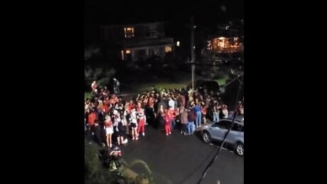 A large crowd gathers on a residential street in Wolfville, N.S., on the day of Acadia University's homecoming. Acadia University homecoming 2021