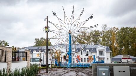 Crews work to dismantle a Ferris wheel in the front yard of a home in Surrey, British Columbia on Wednesday, October 20, 2021. Ferris Wheel Wedding
