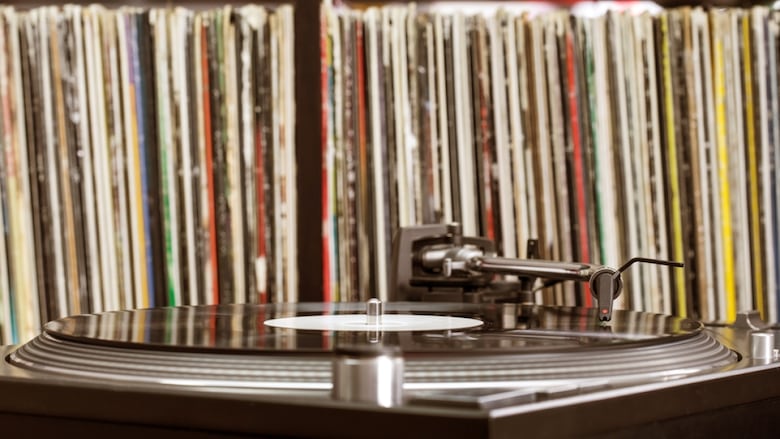 A turntable sits in front of vertically stacked vinyl records