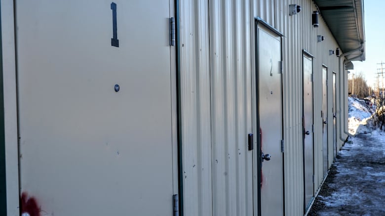 Photo shows building with five separate lockable doors.