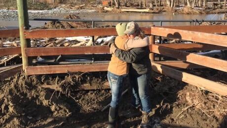 Rhonda MacDonald, right, embraces her friend at Bar FX Ranch in Merritt, B.C., which was washed out in November by floods from the nearby Nicola River. Rhonda MacDonald, right, embraces her friend in her ranch