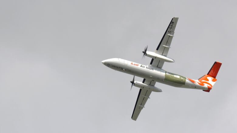 A photo of an Air Inuit air plane from the ground.